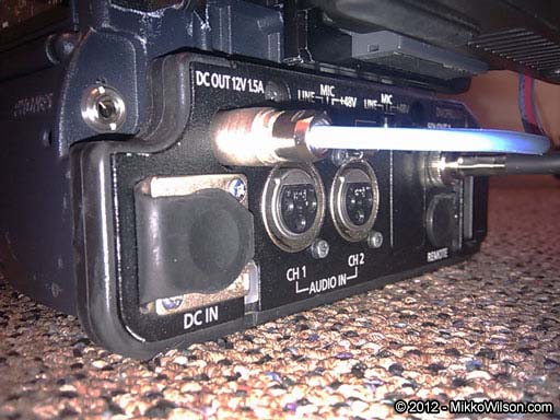 Tally cable connected to the 4-pin Hirose connector on a Panasonic AG-HPX370 camcorder.